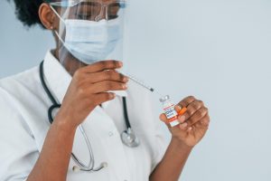 Young african american doctor is against white background